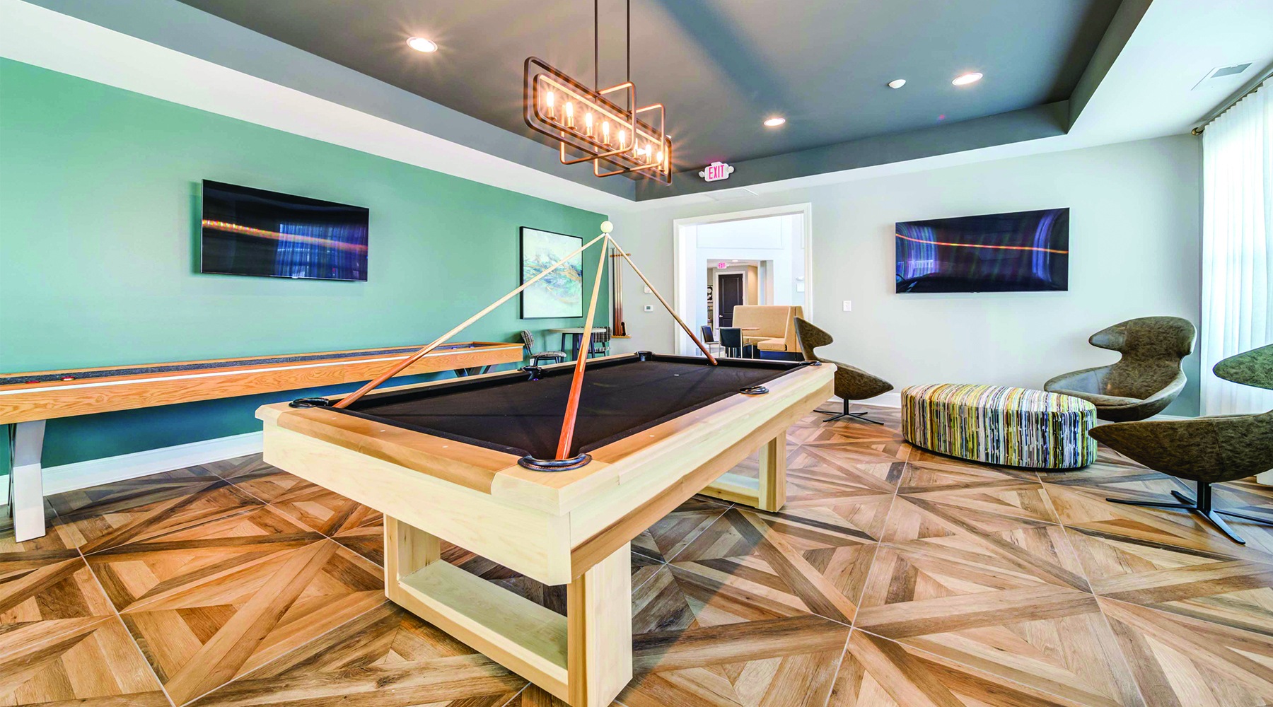 well lit spacious resident lounge with wood floors and pool tables